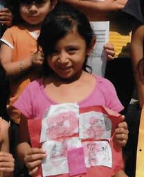 School children show their work at Casa de los Pobres in Tijuana, Mexico